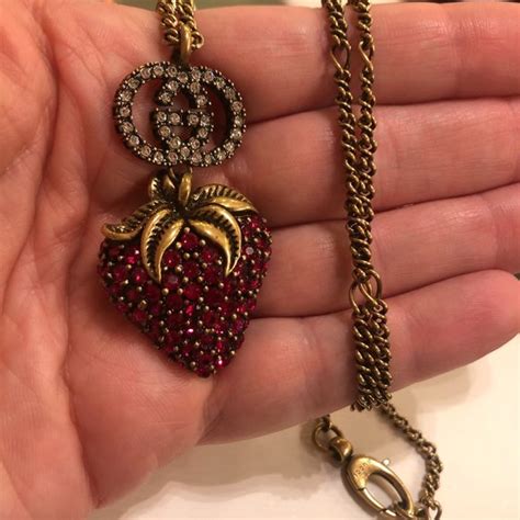 Gucci and strawberry charm necklace .